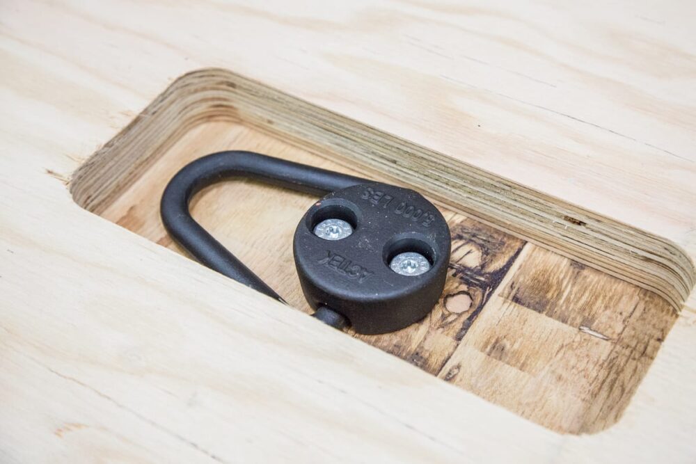 Close-up of a steel tie-down anchor installed in a mass timber panel.