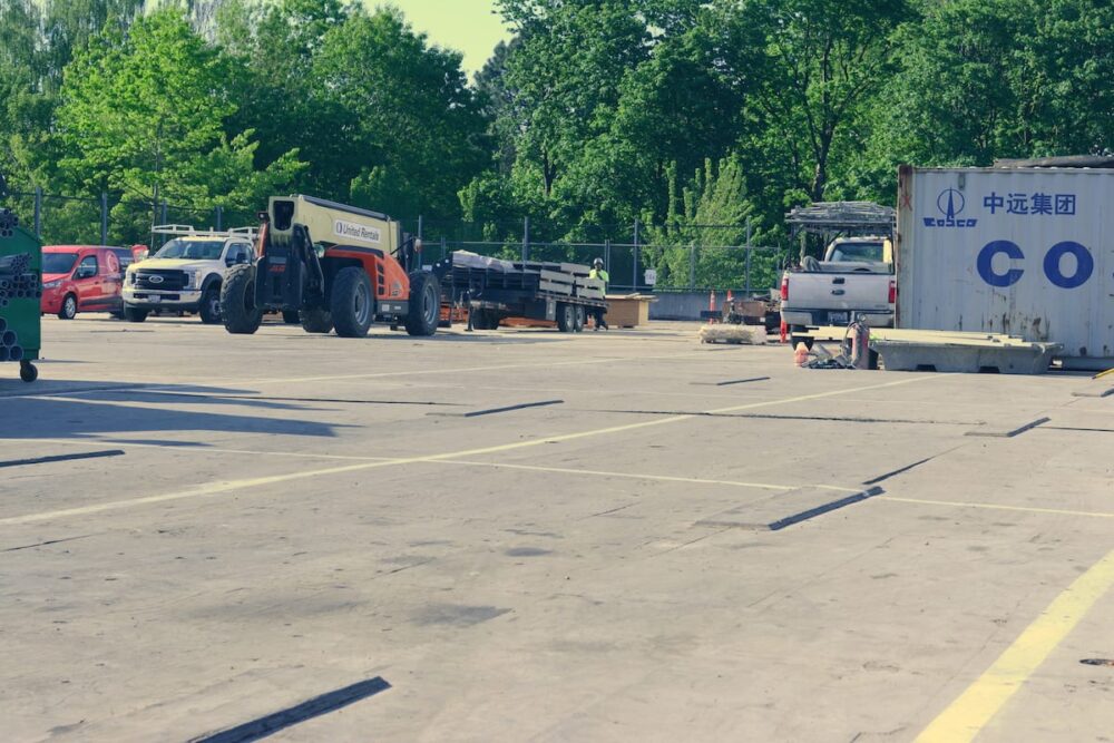 Construction site featuring heavy equipment and materials for a mass timber building project.